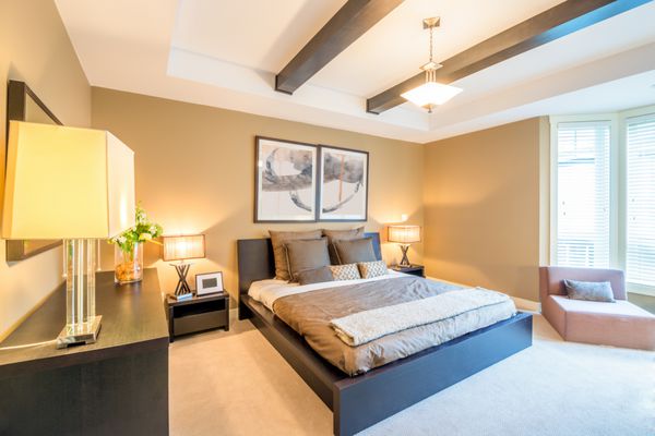 فضای داخلی اتاق خواب مدرن روشن با بالش های طراح در یک خانه لوکس ال