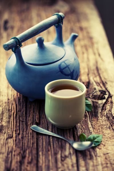ست چای چینی چای گیاهی به سبک چینی روی میز چوبی با مواد خام