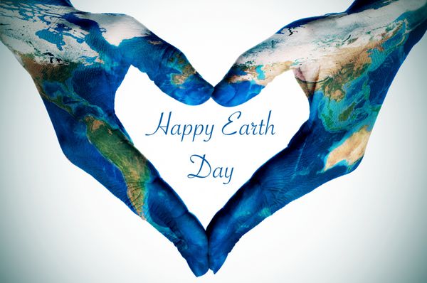 دستان یک زن جوان در حال تشکیل یک قلب با طرح نقشه جهان تجهیز شده توسط ناسا و متن روز زمین مبارک