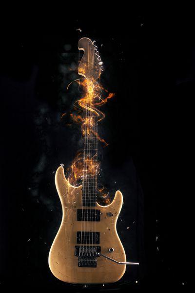 گیتار الکتریک در آتش جدا شده در پس زمینه سیاه