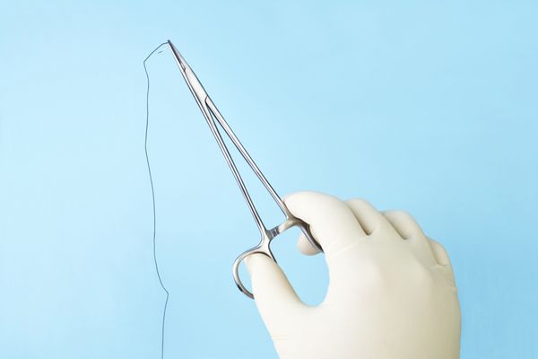 جراح نگهدارنده سوزن جراحی با نخ ابریشمی روی آبی