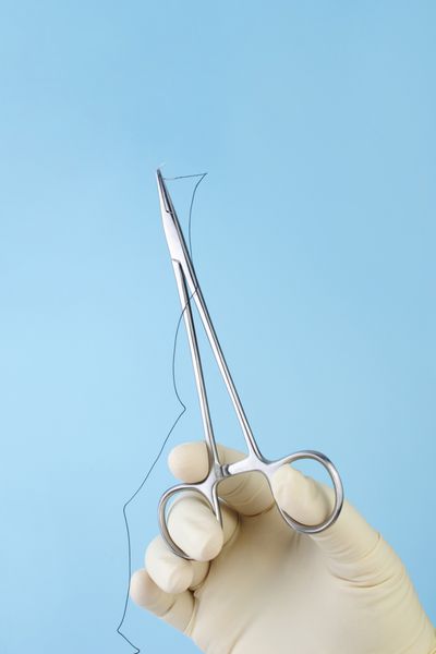 جراح نگهدارنده سوزن جراحی با نخ ابریشمی روی آبی