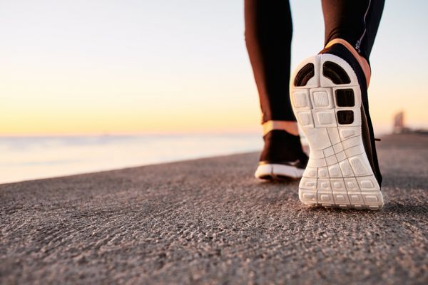 پاهای مرد دونده در حال دویدن در نزدیکی جاده روی کفش ورزشکار تناسب اندام مرد تمرین دویدن در مفهوم سلامتی در طلوع آفتاب مفهوم سبک زندگی سالم ورزشی