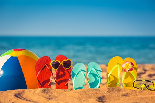 دمپایی توپ ساحلی و اسنورکل روی شن و ماسه مفهوم تعطیلات تابستانی