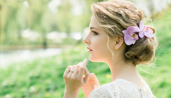 پرتره زن جوان زیبا با گل های بهاری در مو آرایش و مدل مو مدل عروس عروسی