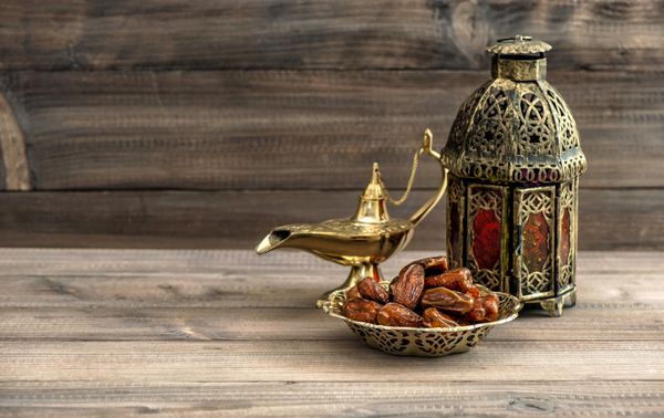 چراغ و خرما ماه رمضان در زمینه چوبی طبیعت بی جان جشن با فانوس شرقی