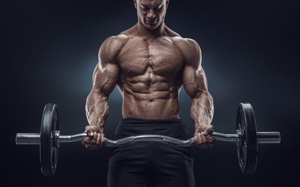 تصویر نزدیک از تمرین یک مرد عضلانی با هالتر در ورزشگاه مرد ورزشکار بدنساز بی رحم با شش تکه شکم کامل شانه ها دوسر سه سر و سینه