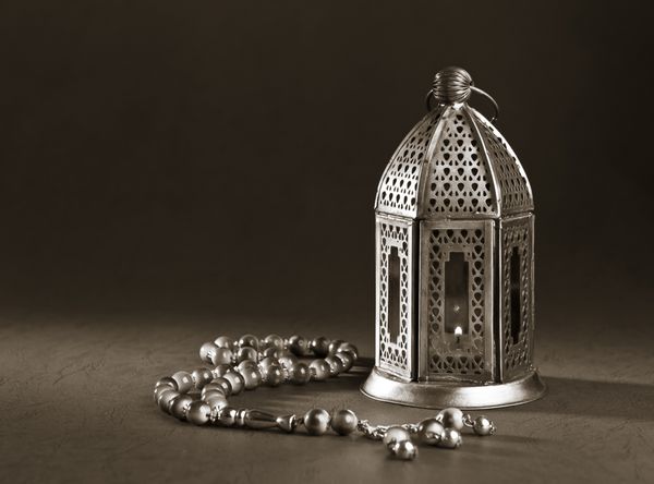 چراغ فلزی ماه رمضان با دانه های تسبیح اسلامی در زمینه مشکی تصویر تک رنگ