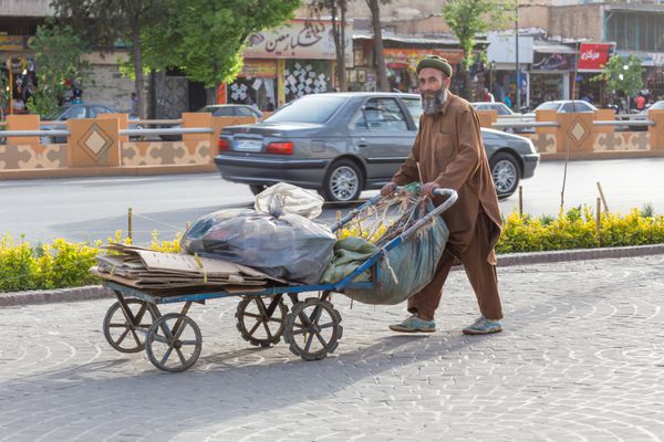 شیراز ایران - 25 آوریل 2015 مردی ناشناس گاری را در خیابان های شیره هل می دهد