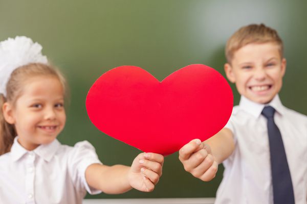 بچه های شاد مدرسه یا بچه هایی که نماد قلب را در کلاس مدرسه نزدیک تخته سیاه در دست دارند آموزش عشق به مدرسه به کودکان بسیار مهم است اما او آن را دوست ندارد به مدرسه خوش آمدید