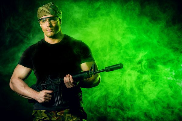 سرباز شجاع در استتار که تفنگ اتوماتیک در دست دارد نظامی
