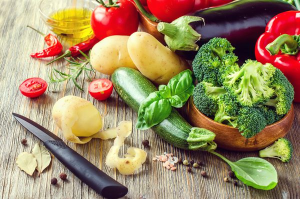 سبزیجات برای پختن شام سالم سیب زمینی پوست کندن میز آشپزخانه غذای گیاهی مواد تازه