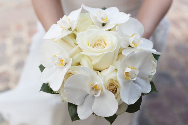دسته گل سفید عروسی رز و ارکیده در دستان عروس