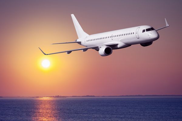 هواپیمای مسافربری در غروب خورشید پرواز می کند