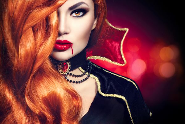 پرتره زن خون آشام هالووین بانوی خون آشام مد زیبا با موهای قرمز بلند آرایش و لباس زیبایی