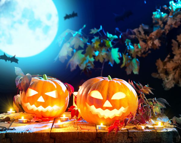 فانوس جک سر کدو تنبل هالووین با شمع های سوزان طراحی هنری تعطیلات هالووین جشن کدو تنبل های هالووین حکاکی شده با شمع های سوزان در جنگل ترسناک عمیق شب