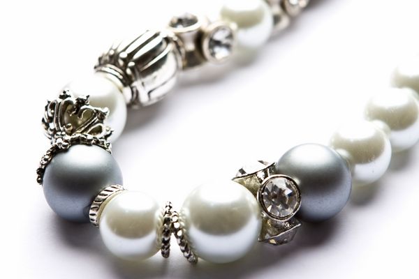 جواهرات لباس طراح نقره و مروارید به صورت ماکرو در پس زمینه سفید