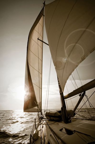 قایق بادبانی به سمت غروب آفتاب - تصویر با رنگ قهوه ای