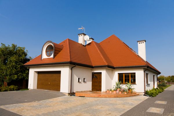 خانه سفید تک خانوادگی با سقف قهوه ای در برابر آسمان آبی