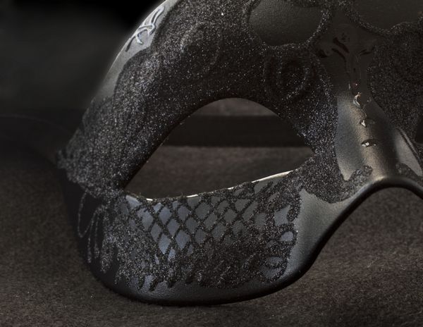 نمای نزدیک بخشی از ماسک سیاه ونیز برای کارناوال روی سیاه