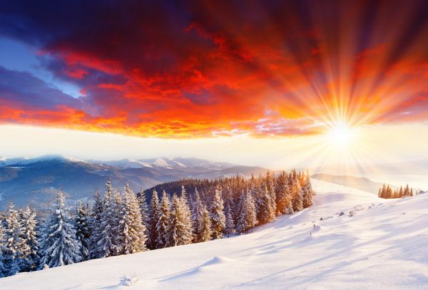 غروب باشکوه خورشید در چشم انداز کوه های زمستانی تصویر hdr