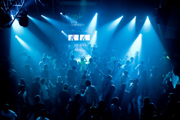 مردم در حال رقص در یک باشگاه زیرزمینی نور صحنه آبی