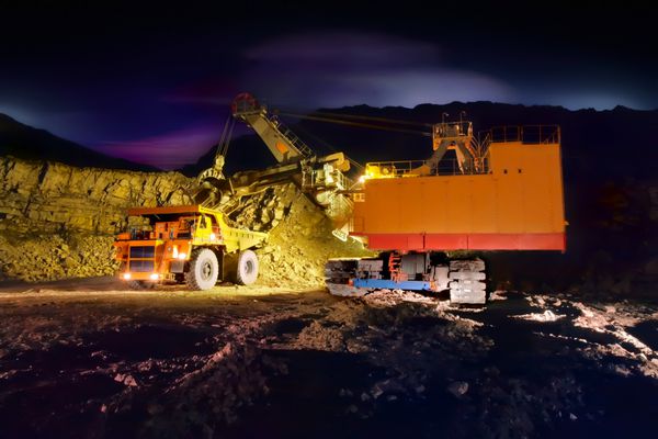 تصویر یک کامیون بزرگ معدن زرد در محل کار شب