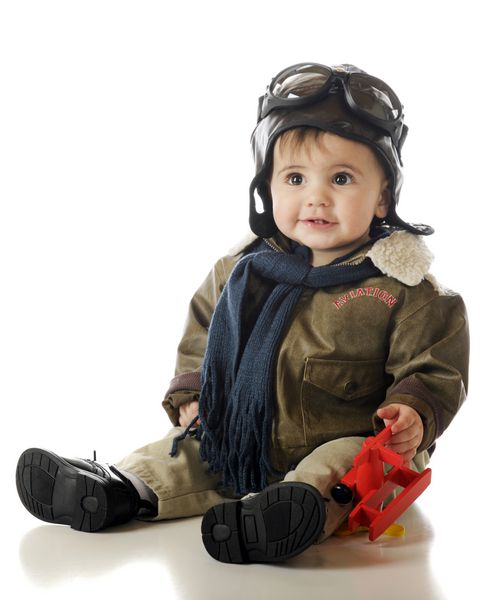 یک نوزاد پسر شایان ستایش که یک هواپیمای اسباب بازی در دست دارد در حالی که عینک کاپوت و عینک خلبانی قدیمی به چشم دارد جدا شده روی سفید