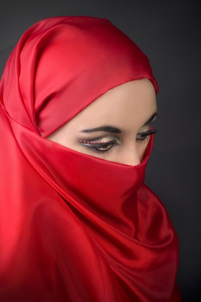پرتره یک دختر جوان عرب با چادر قرمز