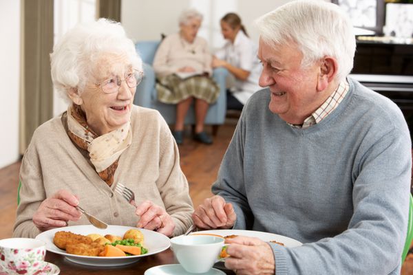 زوج مسن در حال لذت بردن از غذا با هم