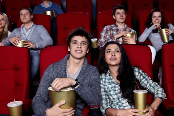 جوانان از نزدیک در حال تماشای یک فیلم در سینما هستند