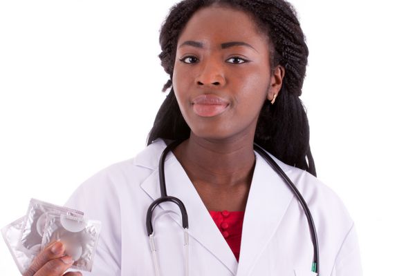 یک زن جوان سیاه پوست با کاندوم در دست