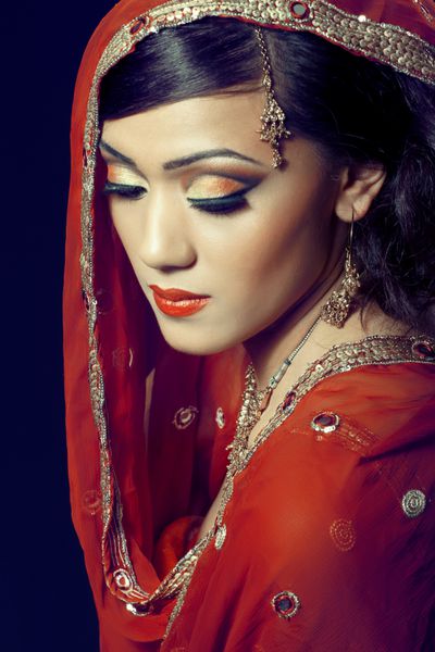 پرتره زیبایی یک زن جوان هندی با لباس سنتی با آرایش عروس و جواهرات نمای نزدیک
