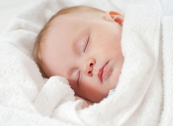 کودک زیر یک پتوی سفید بخوابد