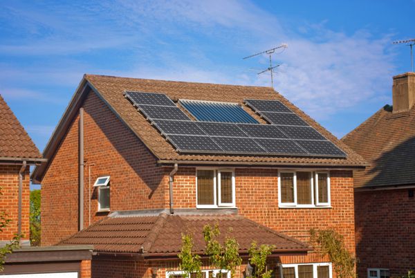 خانه با پنل های خورشیدی روی پشت بام - سیستم انرژی احیا کننده تولید برق