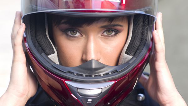 دختر جوان شدید با کلاه ایمنی موتورسیکلت کامل قرمز
