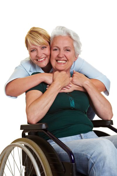 زن شاد در آغوش گرفتن زن سالخورده معلول روی ویلچر