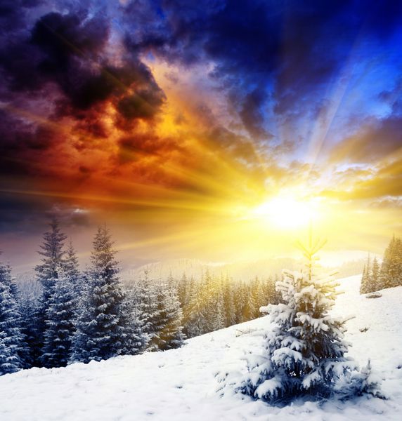 غروب باشکوه خورشید در چشم انداز کوه های زمستانی آسمان دراماتیک
