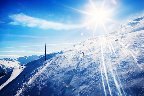 اسکی بازان غیرقابل تشخیص که در غروب آفتاب در کوهستان اسکی می کنند