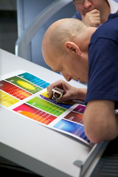 چاپگر از طریق یک عینک برای بررسی ثبت نام در یک تقویم چاپی نگاه می کند