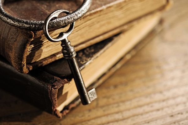 کلیدهای قدیمی روی یک کتاب قدیمی پس زمینه چوبی عتیقه