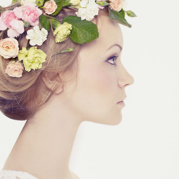 زن جوان زیبا با گلهای ظریف در موهایشان