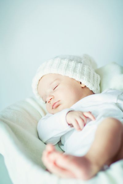 عکس نوزاد تازه متولد شده ای که روی یک پتو خوابیده است
