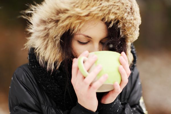 زن با لیوان بزرگ نوشیدنی در روز سرد