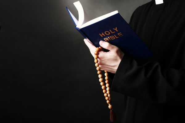 کشیش در حال خواندن از کتاب مقدس از نزدیک