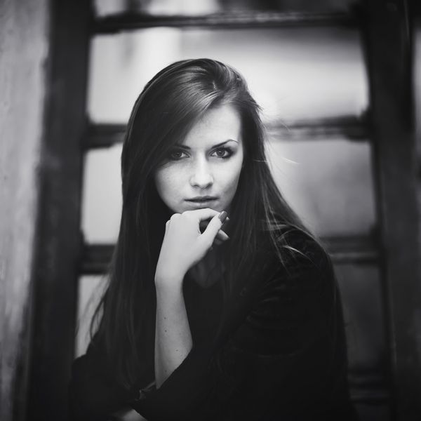 پرتره زن جوان زیبا که روی پله ها نشسته است سیاه و سفید