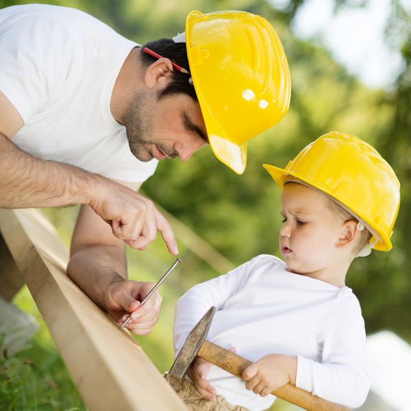 پسر کوچک به پدرش در کارهای ساختمانی کمک می کند