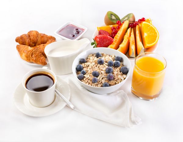 صبحانه سالم با کاسه موسلی قهوه کروسان آب میوه و میوه