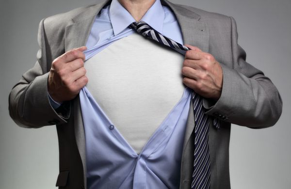 تاجر در ژست سوپرمن کلاسیک در حال پاره کردن پیراهن خود برای نشان دادن تی شرت با سینه خالی برای پیام