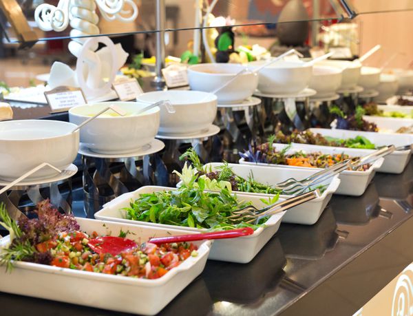 انواع سالادهای تازه که در یک بوفه در ظروف جداگانه در یک رویداد یا جشن با غذا نمایش داده می شوند چشم انداز عقب نشینی